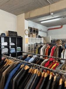 Blick über die Kleiderstangen in die Kleiderkammer